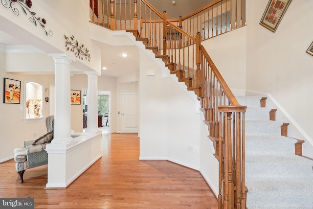 15303 Glastonbury Way, Upper Marlboro, MD 20774 - staircase featuring wood finished floors, ornate columns, a towering ceiling, baseboards, and recessed lighting