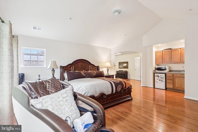 15303 Glastonbury Way, Upper Marlboro, MD 20774 - bedroom featuring refrigerator, arched walkways, vaulted ceiling, and light wood-type flooring