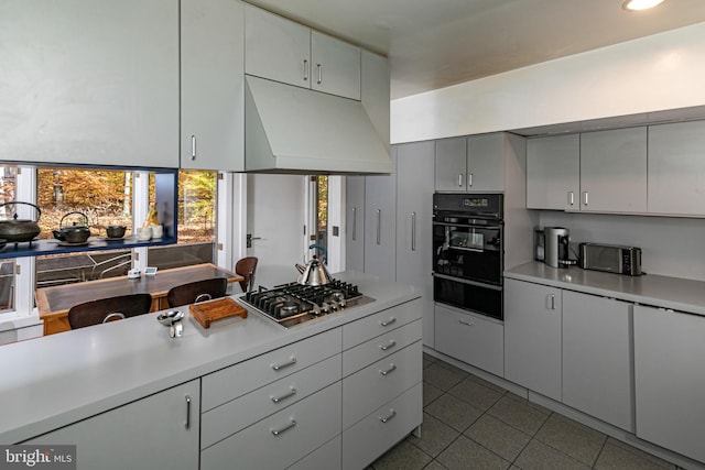 kitchen featuring stainless steel gas stovetop, white cabinetry, and oven