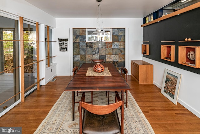 dining space featuring an inviting chandelier and dark hardwood / wood-style floors