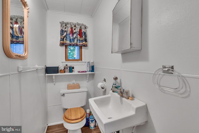 bathroom with toilet, ornamental molding, sink, and hardwood / wood-style floors