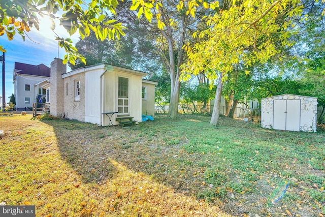 view of yard with an outbuilding, fence, entry steps, and a storage unit