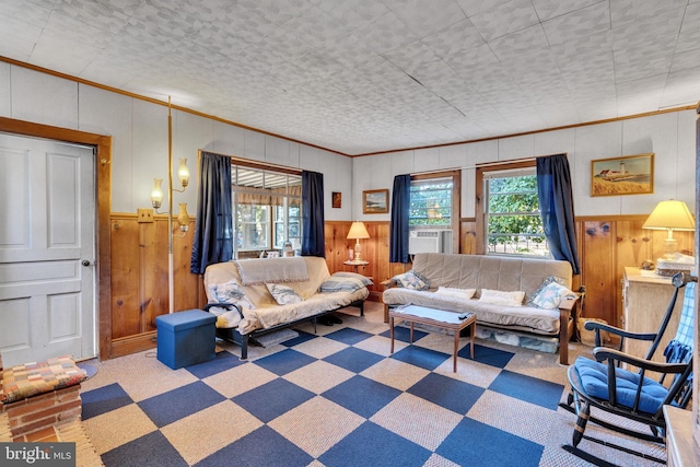 living room with cooling unit, wooden walls, ornamental molding, and carpet floors