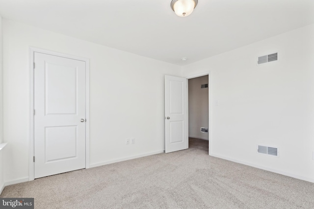 unfurnished bedroom featuring light carpet, baseboards, and visible vents