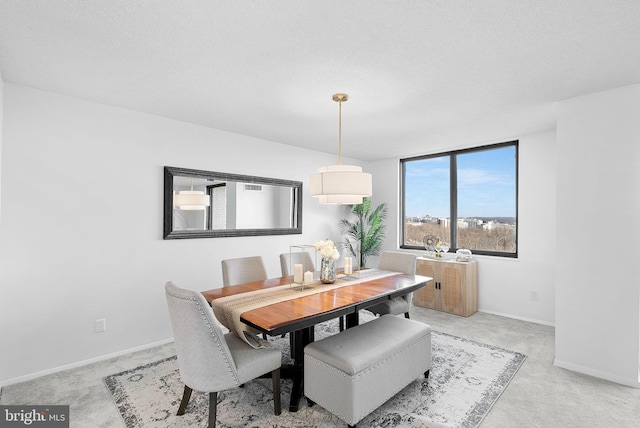 carpeted dining area featuring a textured ceiling