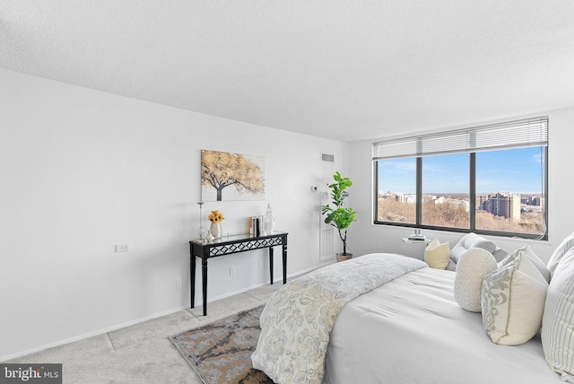 bedroom featuring light carpet and a textured ceiling