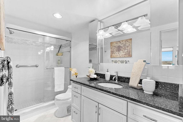 bathroom featuring an enclosed shower, vanity, decorative backsplash, and toilet