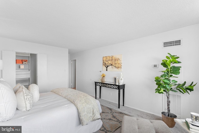 carpeted bedroom featuring a textured ceiling