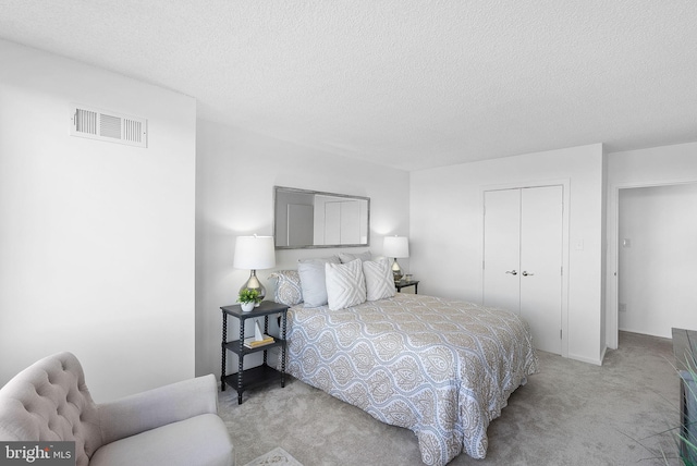 carpeted bedroom with a closet and a textured ceiling