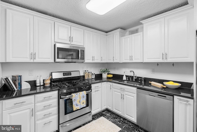 kitchen with stainless steel appliances, sink, a textured ceiling, and white cabinets