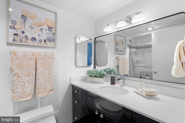 bathroom featuring walk in shower, vanity, and toilet