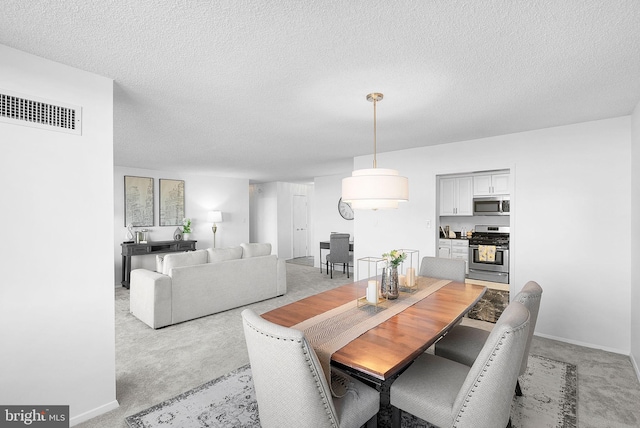 carpeted dining room with a textured ceiling