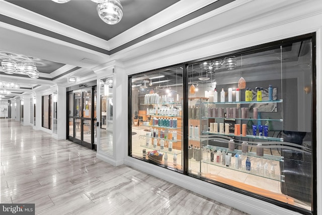 interior space with ornamental molding, a raised ceiling, and indoor bar