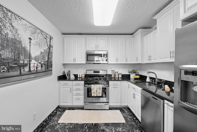 kitchen featuring white cabinetry, appliances with stainless steel finishes, sink, and a textured ceiling