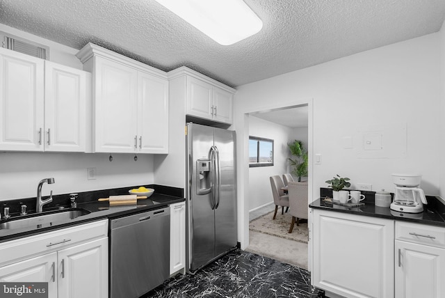 kitchen featuring white cabinetry, appliances with stainless steel finishes, sink, and a textured ceiling