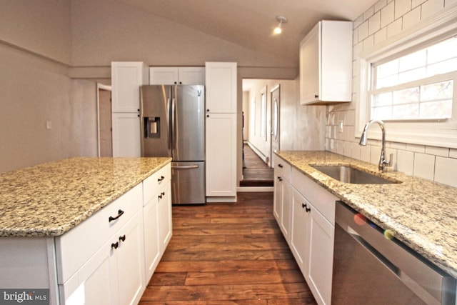 kitchen featuring appliances with stainless steel finishes, white cabinetry, sink, and vaulted ceiling