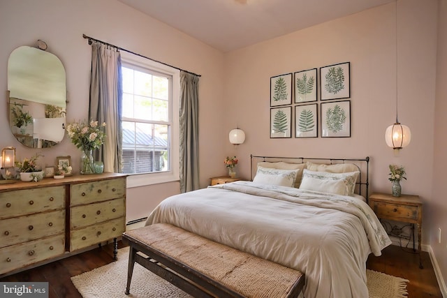 bedroom featuring baseboard heating and dark hardwood / wood-style flooring