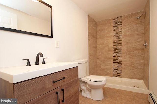 bathroom with a baseboard radiator, toilet, tiled shower, vanity, and tile patterned floors