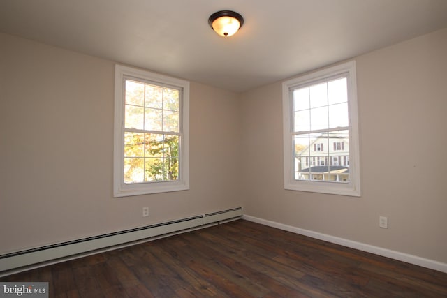 unfurnished room featuring a baseboard heating unit and dark wood-type flooring