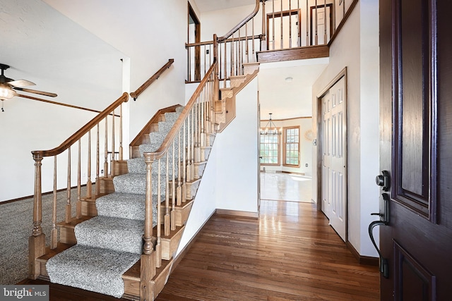 foyer entrance with a high ceiling, an inviting chandelier, and dark hardwood / wood-style flooring