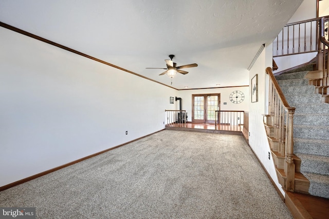 unfurnished living room featuring ornamental molding, carpet, french doors, and ceiling fan