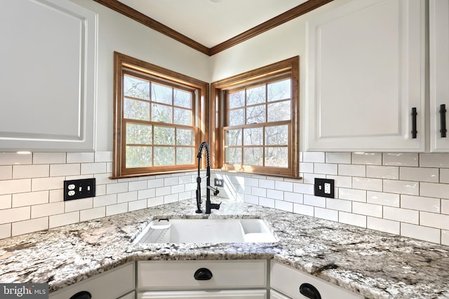 kitchen featuring ornamental molding, decorative backsplash, white cabinets, and sink