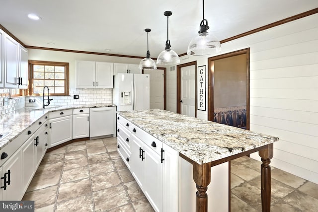 kitchen with a kitchen island, white cabinets, decorative light fixtures, and white appliances