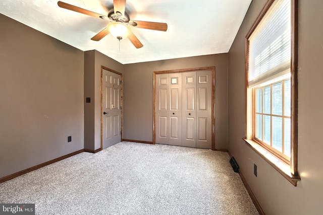 unfurnished bedroom with ceiling fan, multiple windows, and light colored carpet