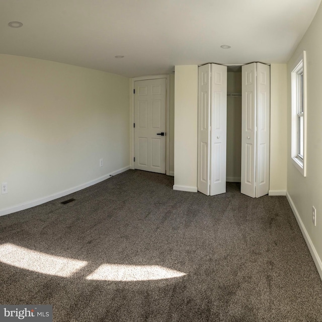 unfurnished bedroom featuring dark carpet