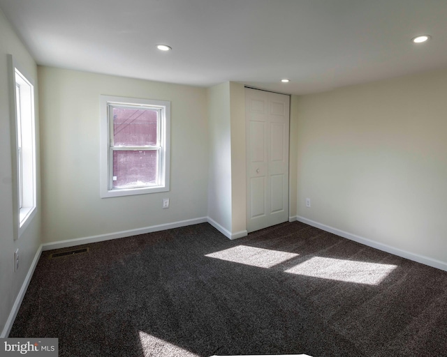 unfurnished room with dark carpet