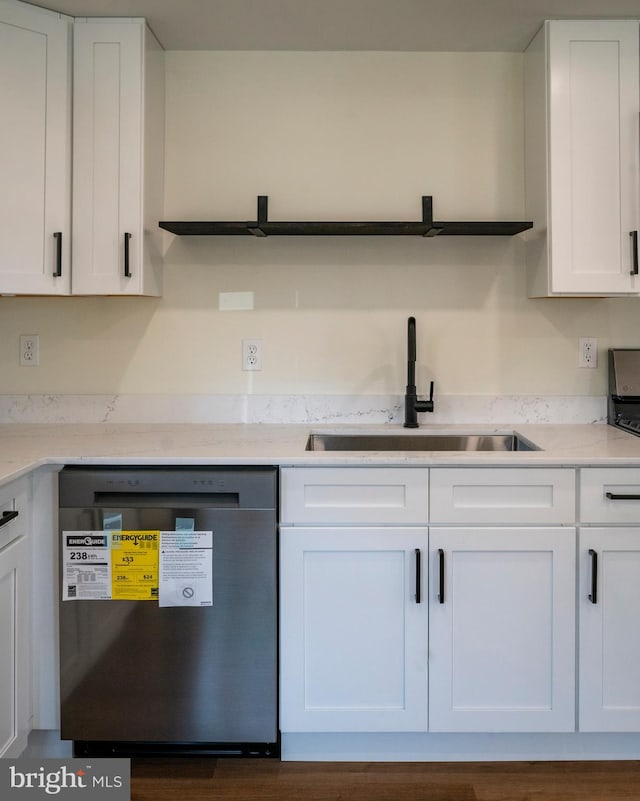 kitchen with sink, dishwasher, white cabinetry, light stone counters, and dark hardwood / wood-style floors