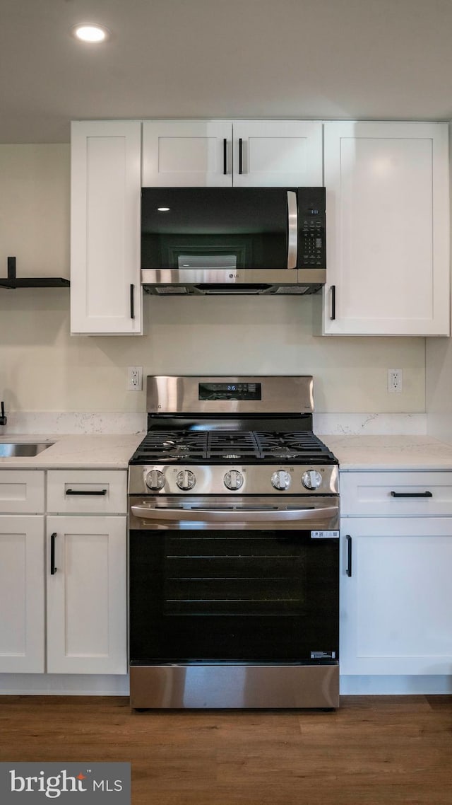 kitchen with white cabinetry, light stone counters, and stainless steel appliances