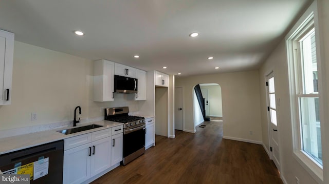 kitchen featuring light stone countertops, sink, appliances with stainless steel finishes, and white cabinetry