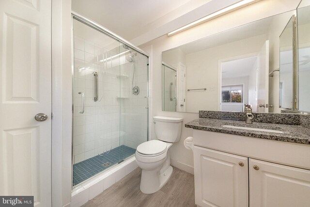 bathroom with vanity, hardwood / wood-style flooring, toilet, and walk in shower