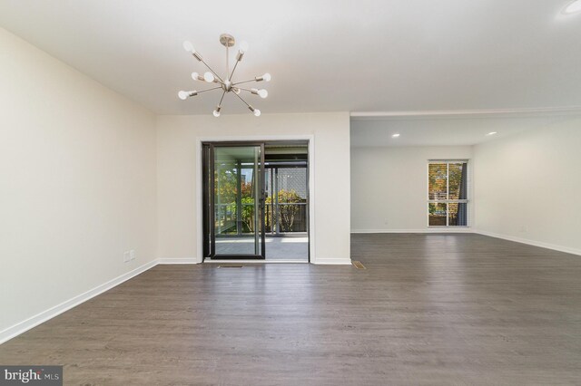 unfurnished room with dark hardwood / wood-style flooring and an inviting chandelier