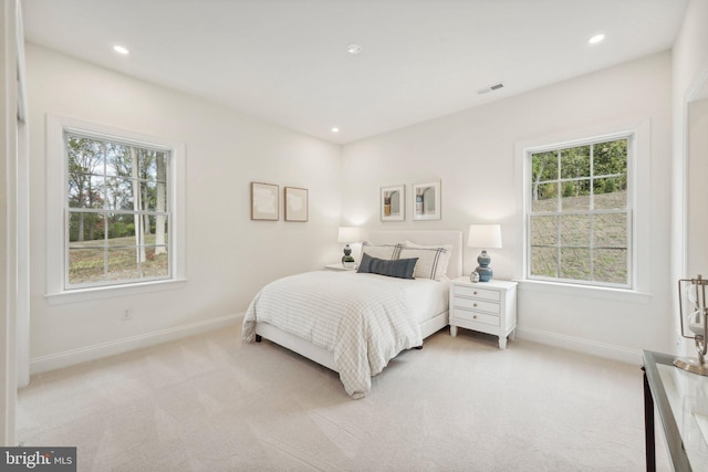 bedroom featuring multiple windows and light colored carpet