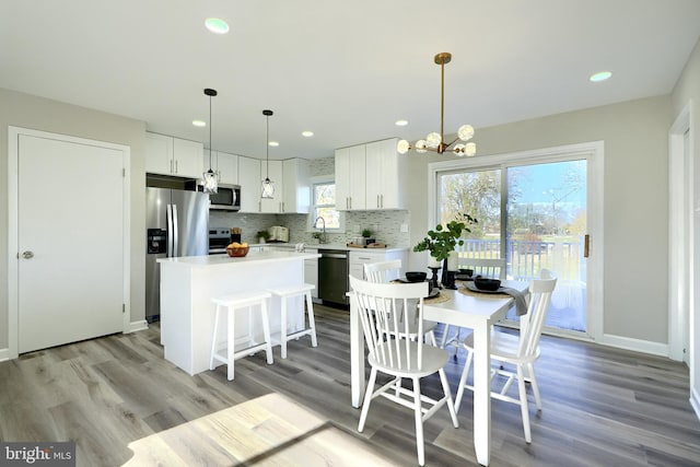 dining space featuring a chandelier, sink, and light hardwood / wood-style flooring