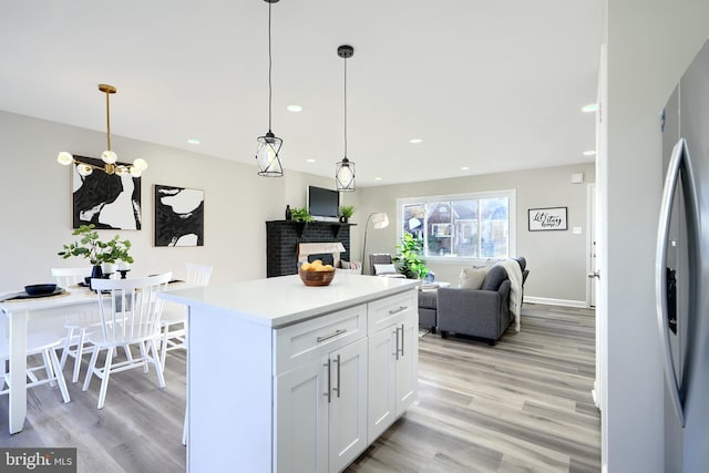 kitchen featuring light hardwood / wood-style floors, white cabinetry, and pendant lighting