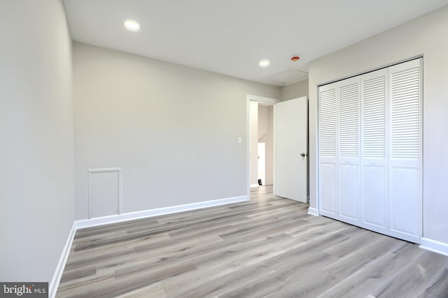 unfurnished bedroom with a closet and light wood-type flooring