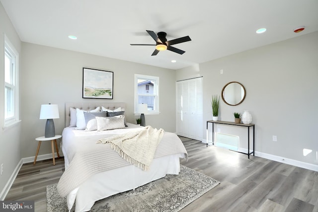 bedroom with hardwood / wood-style floors, ceiling fan, and a closet