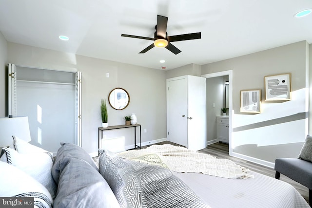 bedroom with hardwood / wood-style floors, ceiling fan, and ensuite bath