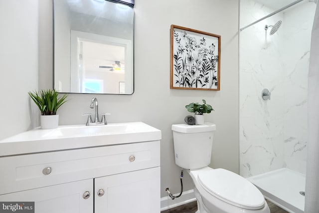 bathroom featuring tiled shower, toilet, and vanity