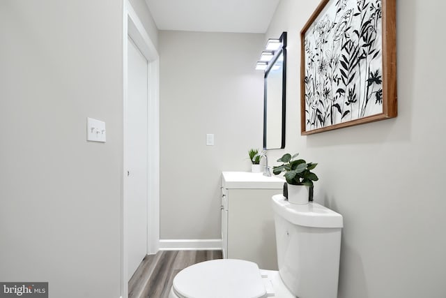 bathroom featuring wood-type flooring, vanity, and toilet