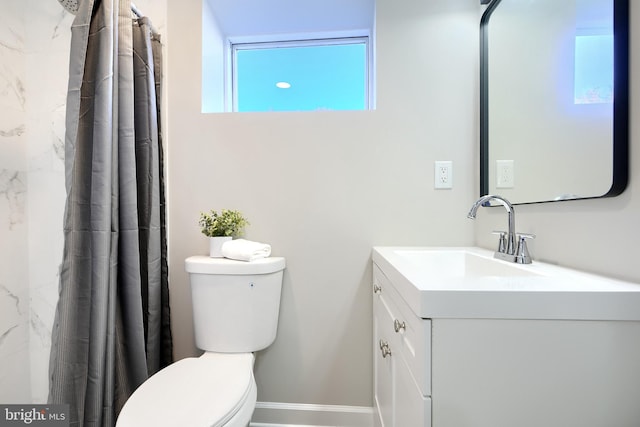 bathroom featuring toilet, vanity, and curtained shower