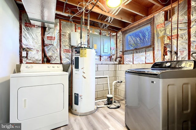 laundry room with electric water heater, light wood-type flooring, and washer and clothes dryer