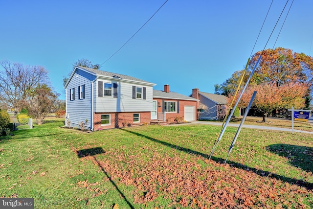 split level home featuring a garage and a front lawn