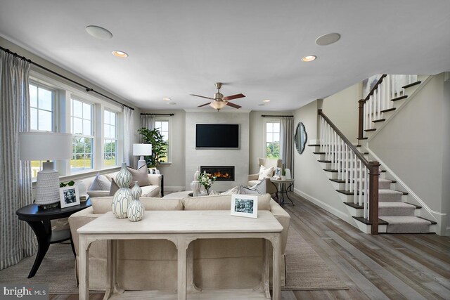 living room featuring hardwood / wood-style floors, a healthy amount of sunlight, a fireplace, and ceiling fan