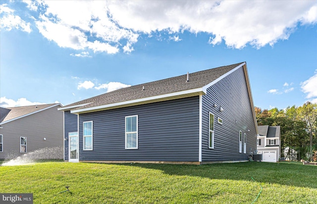 rear view of property featuring a lawn and a garage