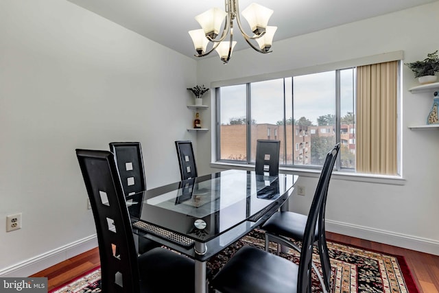 dining space with hardwood / wood-style flooring and a chandelier