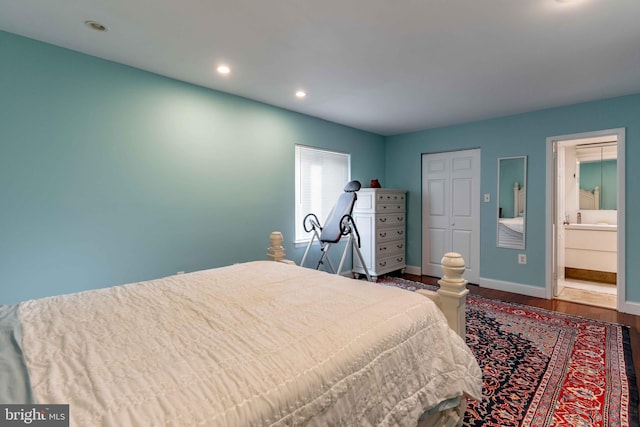 bedroom featuring a closet, ensuite bathroom, and hardwood / wood-style floors